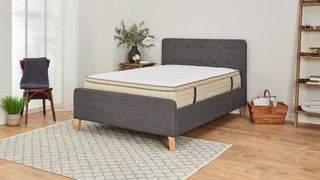 The DreamCloud Luxury Hybrid mattress placed on a dark grey storage bed frame