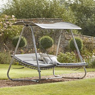 swinging lounger with garden area and plants