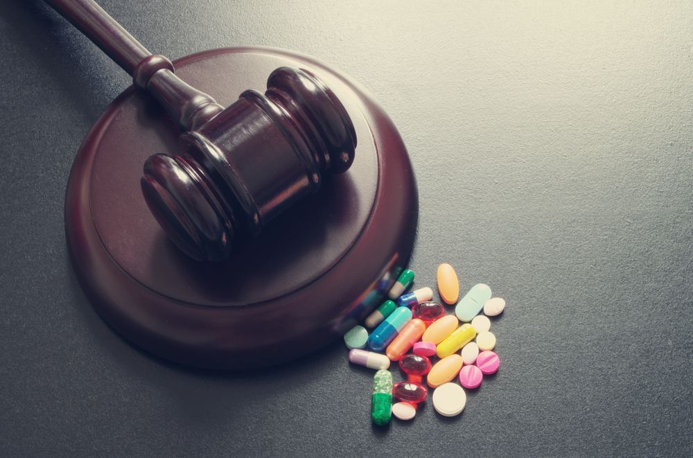 Gavel sitting beside a pool of prescription drugs