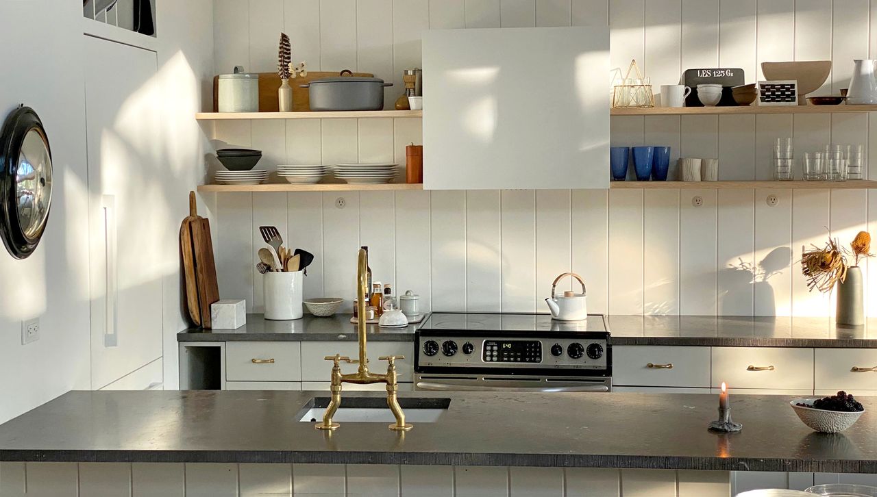 Jenna Lyons&#039; beach house kitchen with black surfaces and white paint 