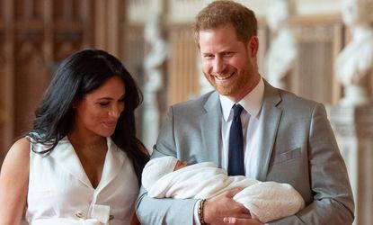 Britain's Prince Harry, Duke of Sussex (R), and his wife Meghan, Duchess of Sussex, pose for a photo with their newborn baby son, Archie Harrison Mountbatten-Windsor, in St George's Hall at Windsor Castle in Windsor, west of London on May 8, 2019. 