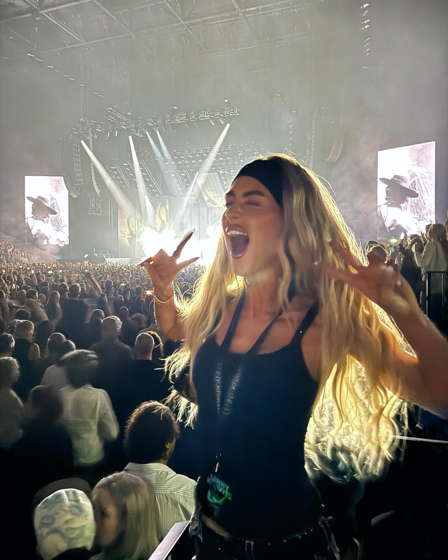 A woman at a concert dancing in the crowd