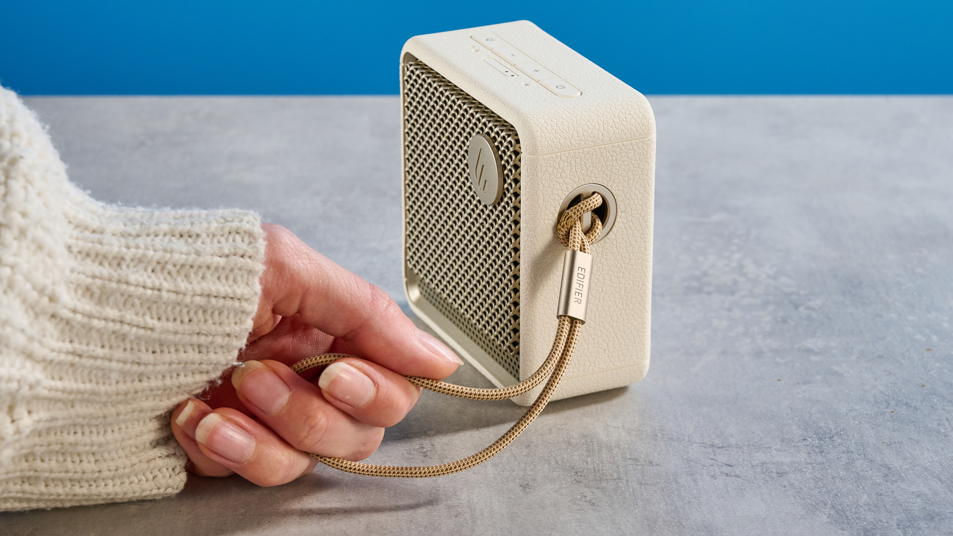 Edifier ES20 Bluetooth speaker in ivory colorway photographed on a blue background