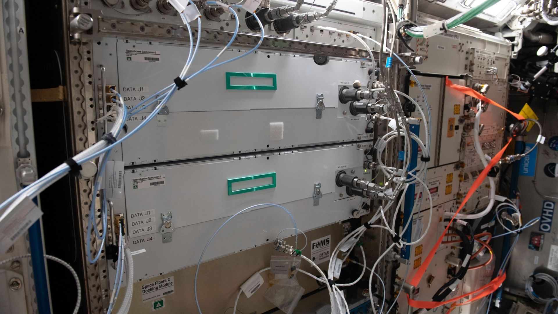 Two HPE Spaceborne Computer-2 units mounted in an equipment rack aboard the International Space Station, surrounded by cables.