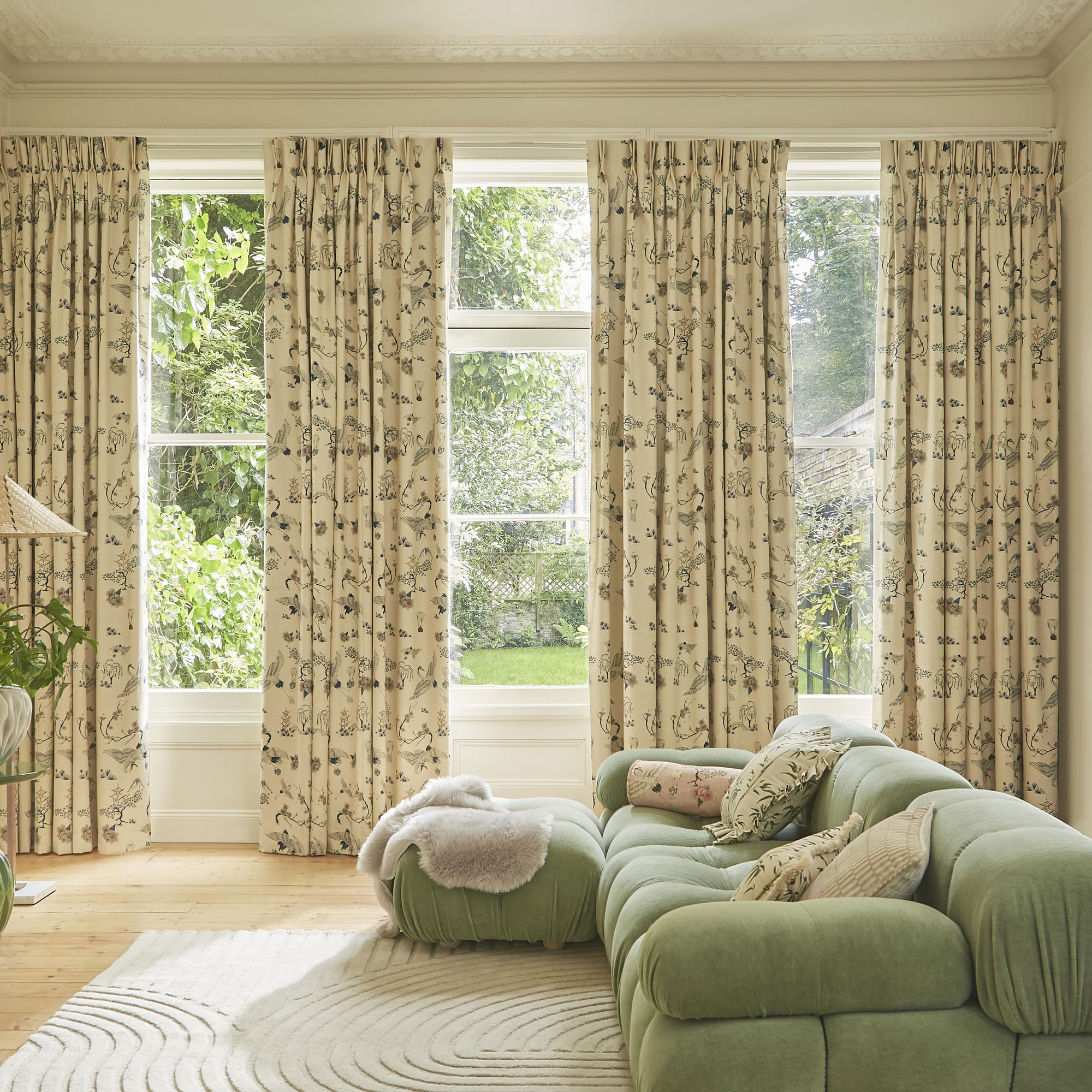 traditional living room with green cloud sofa and full length floral curtains