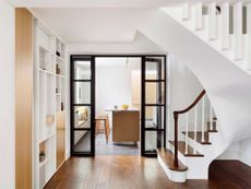 a kitchen through a hallway with glass doors