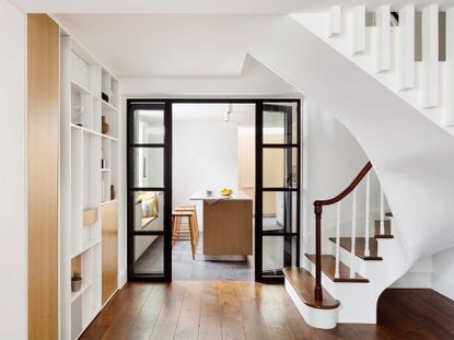 a kitchen through a hallway with glass doors