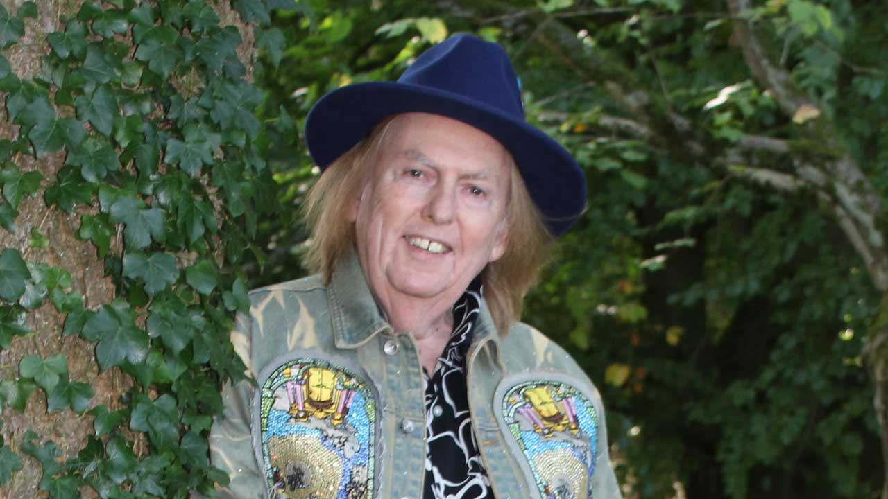 Dave Hill standing in front of a hedge