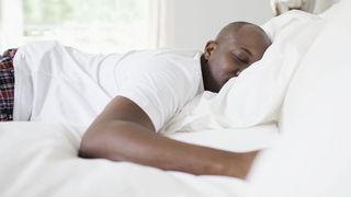 Man lying face down asleep in bed