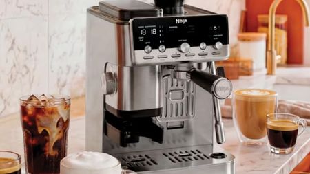 Ninja Luxe Cafe Mini Plus Auto froth machine on a marble counter surrounded by glass cups of coffee