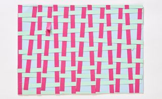 Criss-cross thread design in pink and green on a blue background made out of paper