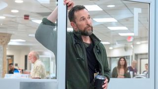 Dr. Robby leans on a door frame