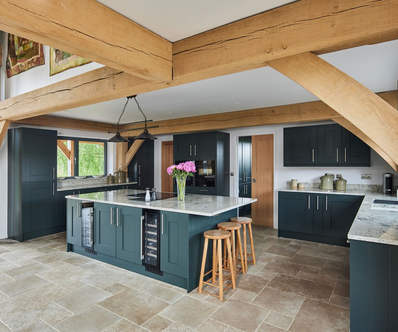 A newly fitted kitchen in an oak-frame home with marble-effect counter tops and a kitchen island with bar seating