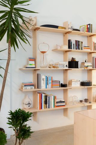 View of the wooden bookshelf with books and other items on it at the Formafantasma Milan studio