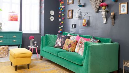 room with grey wall and green sofa 