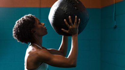 Shoulder workouts: A woman lifting a weighted ball