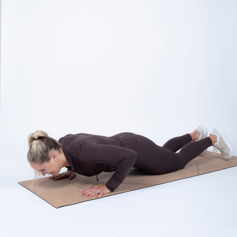 Sarah Campus demonstrating how to do a push up on your knees, second position lying on the floor