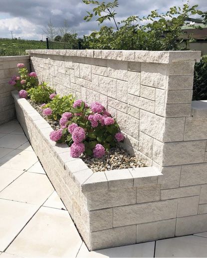 White stone garden wall ideas with planter