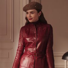 Lily Collins wearing a leather jacket and a beret 