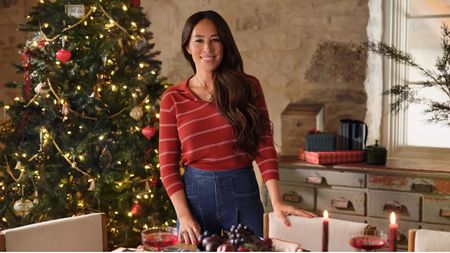 Joanna Gaines in dining room with a christmas tree and antique drawers in background
