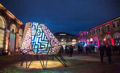 Lit up structures in a busy courtyard 