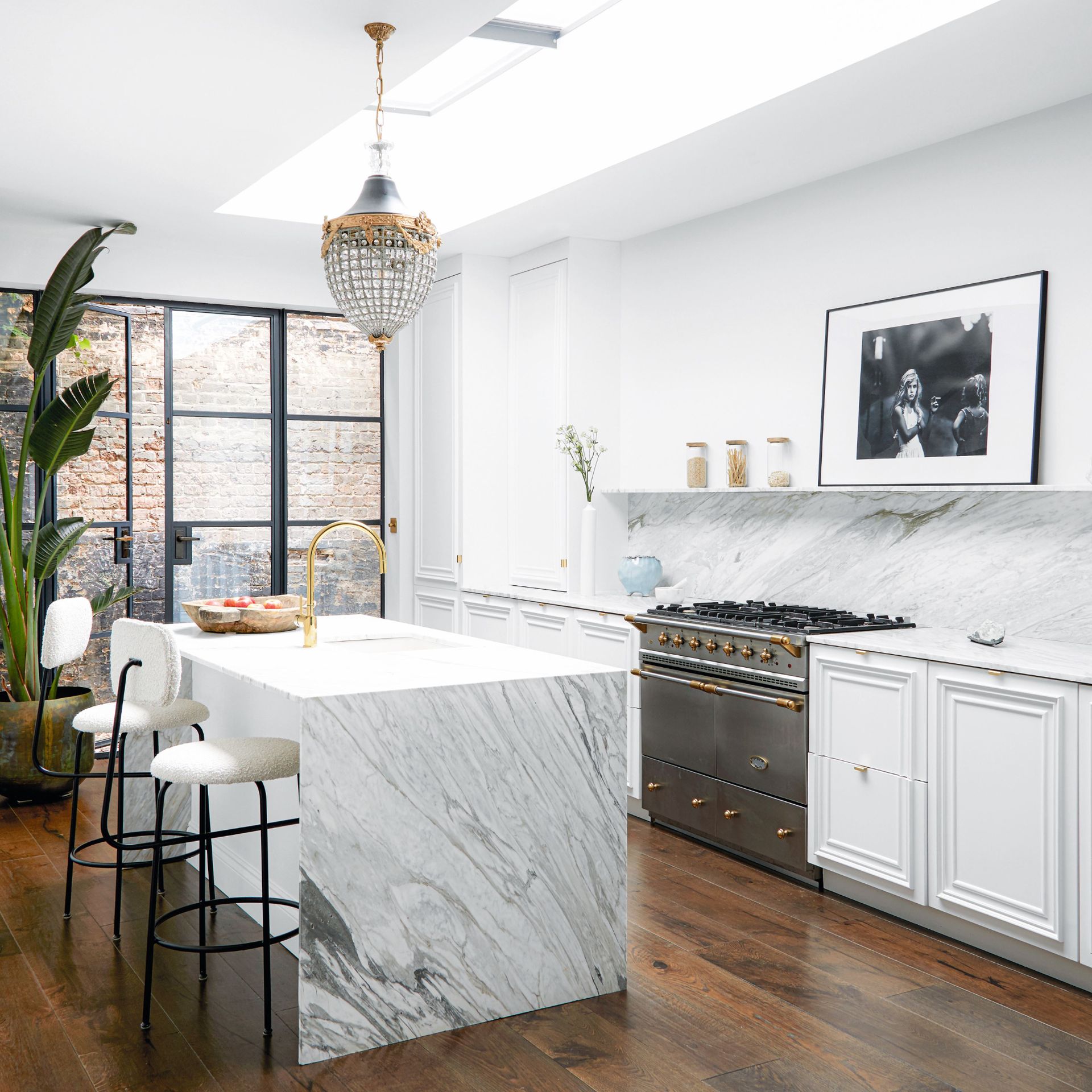 Kitchen with marble kitchen island and worktops, white colour scheme, open shelving