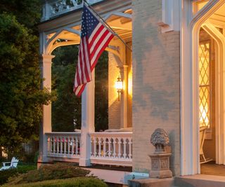 Exterior lighting and a US flag on a Gothic Revival home