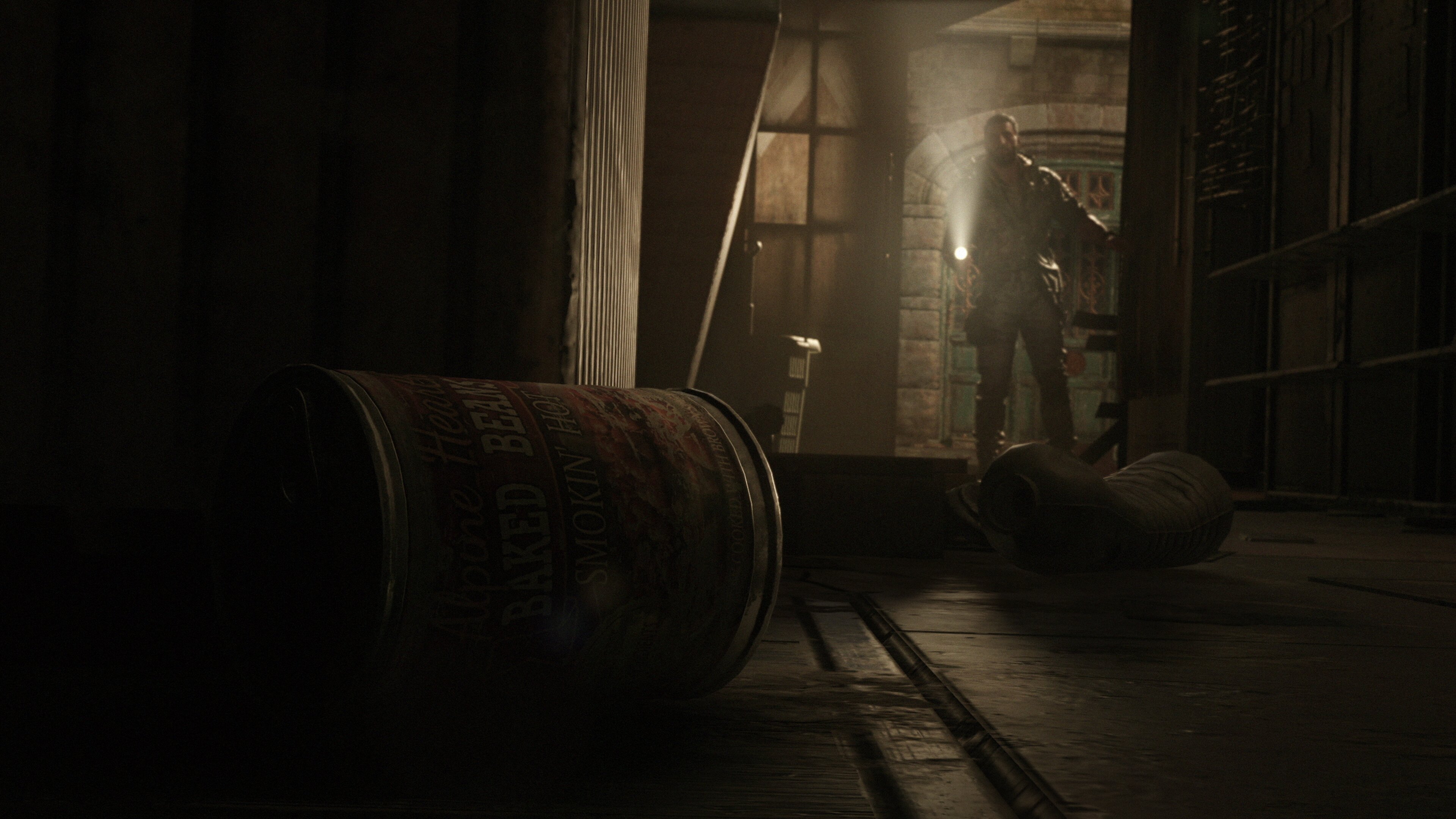 Dying Light the Beast restored land update official screenshot of Kyle in a dark room looking at discarded cans of food