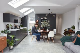 Concrete flooring in open plan living space with gray cololr scheme and roof lanterns