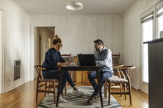 Side view of couple paying bills
