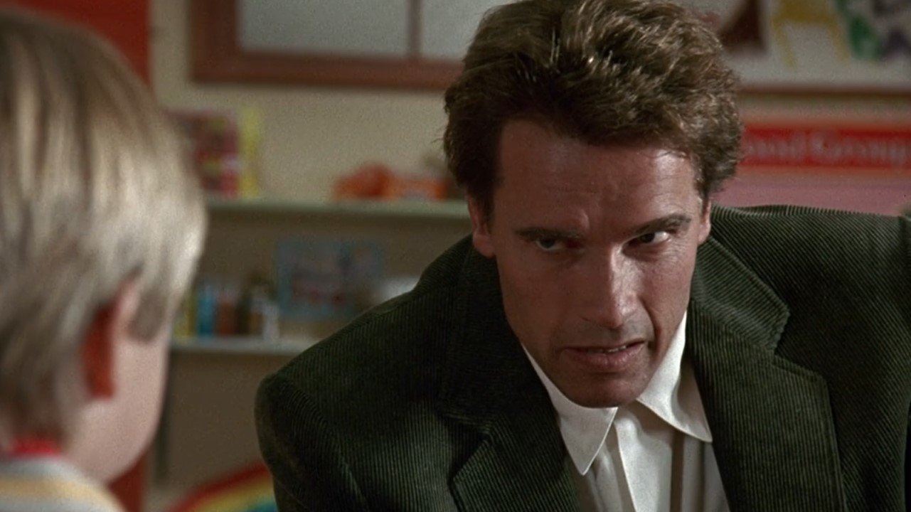 Arnold Schwarzenegger staring angrily at a kid in Kindergarten Cop