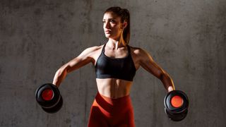a woman lifting two dumbbells