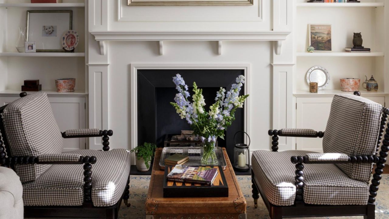 White walled living room with black gingham accent chairs and a wooden coffee table