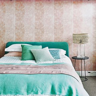 Bedroom with pink wallpaper and teal bedding