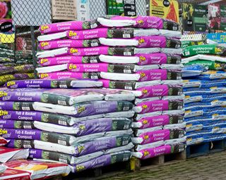 bags of compost on sale at a garden center