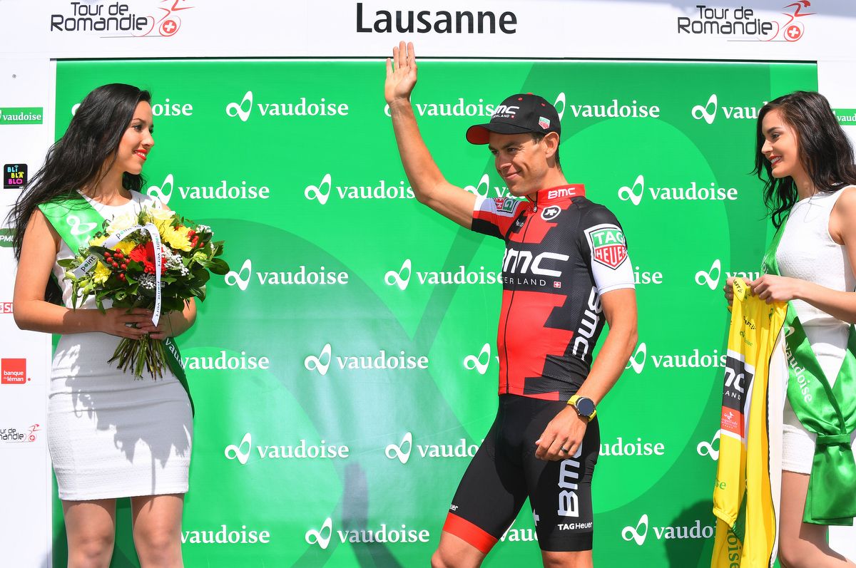 Richie Porte waves from the podium on route to collecting yellow