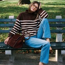 Woman in dark brown stripe sweater and jeans