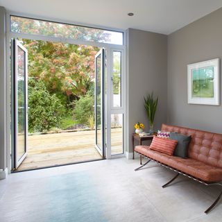 Grey living area with leather sofa and French doors leading out to garden