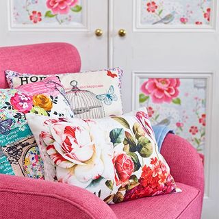 gorgeous pink chair and pile of floral print cushions