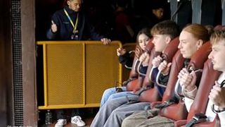 Younger guests get ready as they are strapped into a roller coaster. 