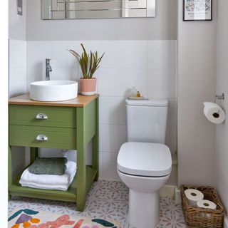 Bathroom with white sink on green vanity unit