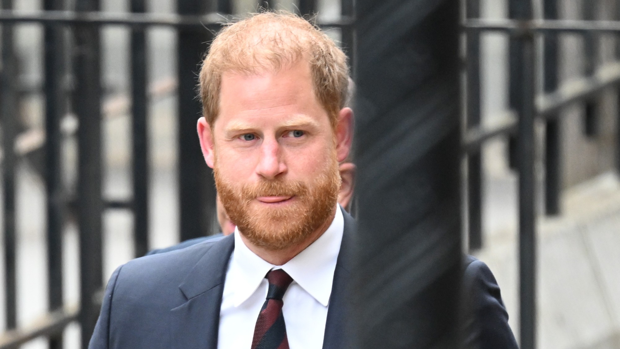 The Duke of Sussex, Prince Harry, in front of railings, with his tongue half out
