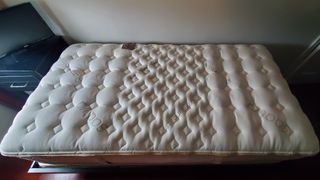 Saatva RX mattress review image shows the bed planed on a black frame at our lead tester's apartment
