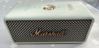 The Marshall Emberton III portable Bluetooth speaker in sage green on a patterned counter