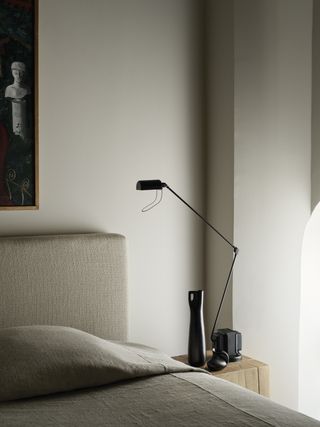 a minimalist table lamp on a nightstand in a neutral bedroom