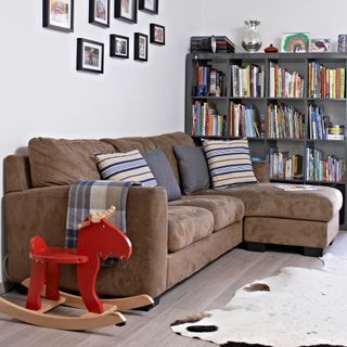 A living room with a brown suede sofa