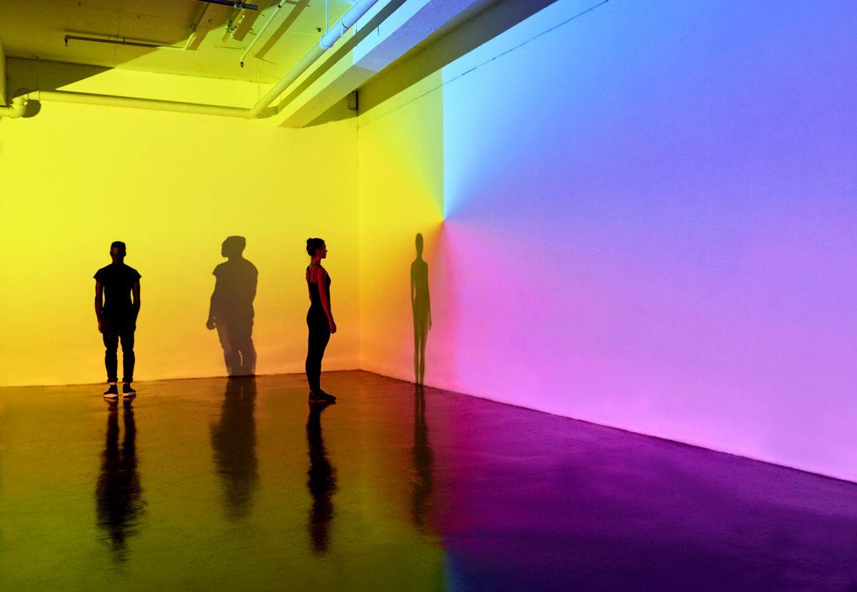 Man and woman standing in a gallery space with colourful walls