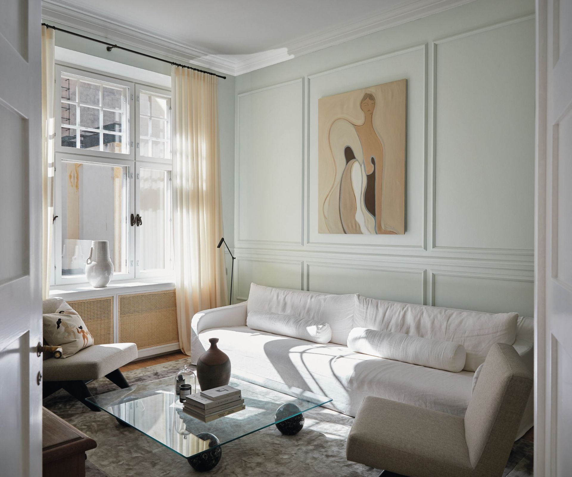 White sofa, grey rug, glass coffee table, black light