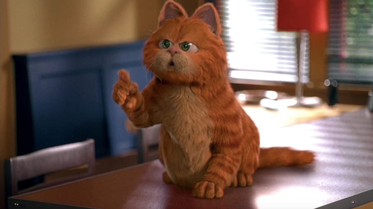 Garfield the cat speaking on the table, with his finger in the air, in Garfield: The Movie.