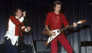 Johnny Rotten (left) and Steve Jones perform live onstage with the Sex Pistols at Dunstable's Queensway Hall in 1976
